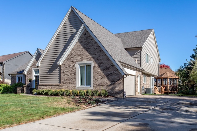 view of property exterior with a garage, a gazebo, central AC unit, and a yard