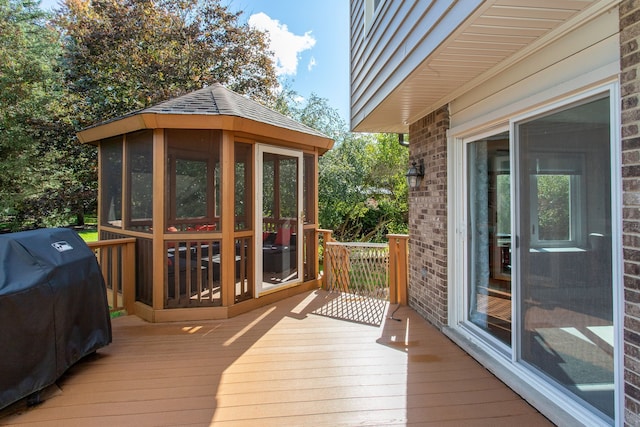 deck with a sunroom and a grill