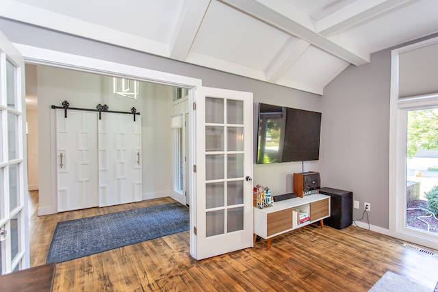 foyer featuring hardwood / wood-style flooring, lofted ceiling with beams, french doors, and a barn door