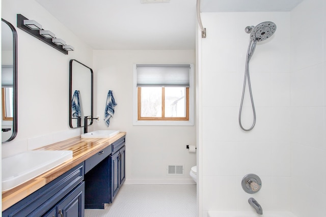 full bathroom featuring toilet, tiled shower / bath, and vanity