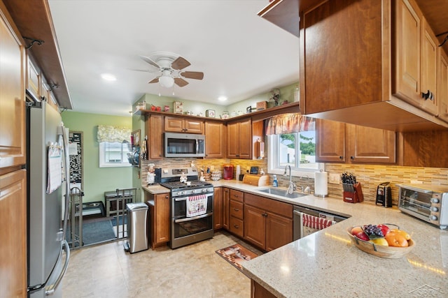 kitchen featuring sink, stainless steel appliances, light stone counters, and backsplash