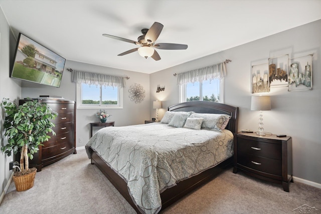 bedroom featuring light carpet, multiple windows, and ceiling fan