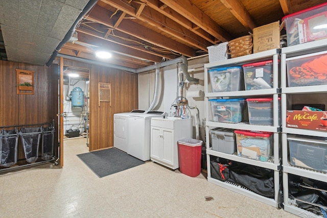 basement with wood walls and washer and clothes dryer