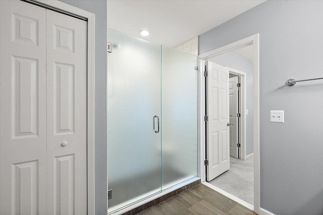 bathroom featuring hardwood / wood-style flooring and a shower with door