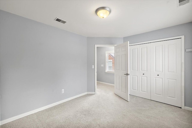 unfurnished bedroom featuring a closet and light carpet