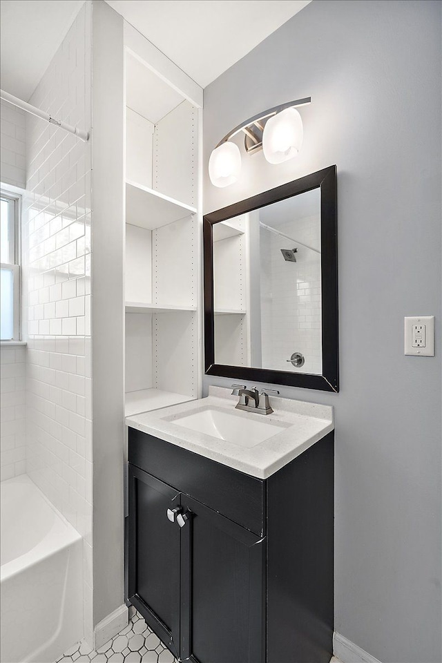 bathroom with tile patterned floors, vanity, and tiled shower / bath