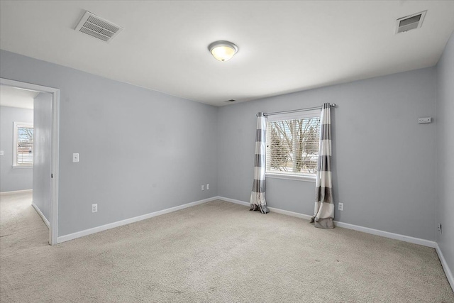 unfurnished room featuring light carpet