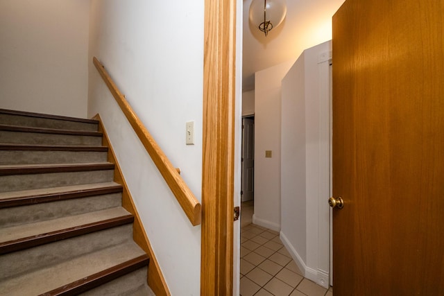 stairway featuring baseboards and tile patterned floors