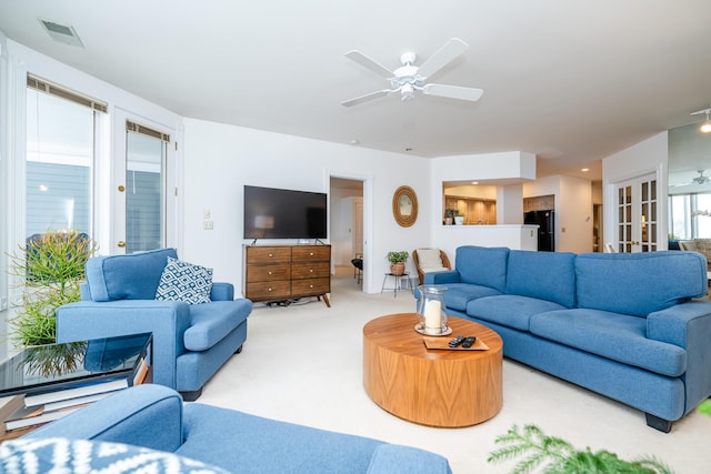 living area featuring french doors, carpet, visible vents, and a ceiling fan