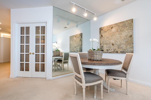 carpeted dining space featuring french doors