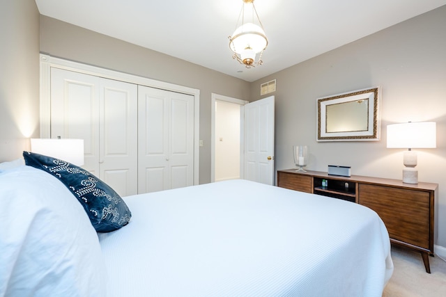 bedroom with visible vents, a closet, and light colored carpet