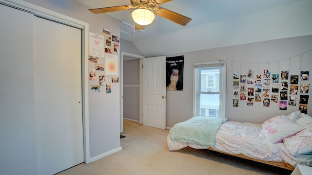 carpeted bedroom with a closet, ceiling fan, and lofted ceiling