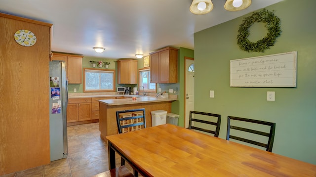 kitchen featuring sink, kitchen peninsula, and stainless steel fridge