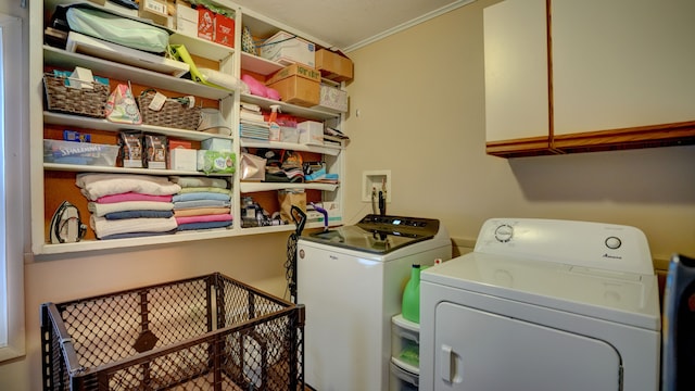 washroom featuring cabinets, separate washer and dryer, and crown molding