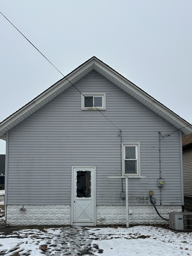 view of snowy exterior with central AC unit