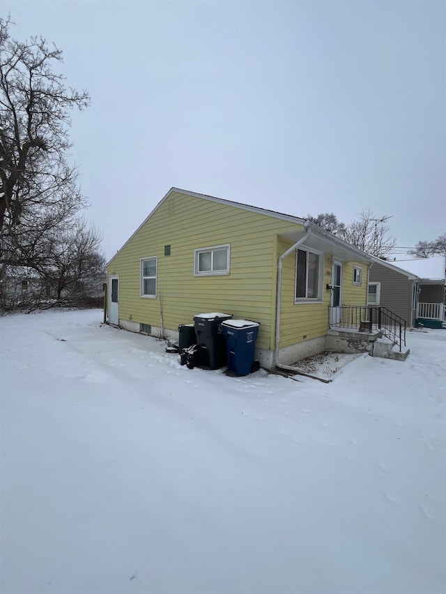 view of snow covered rear of property