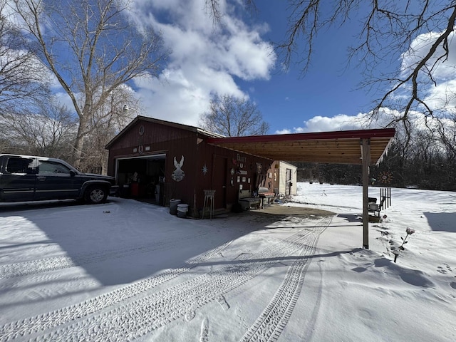 view of snow covered exterior featuring a carport and a garage