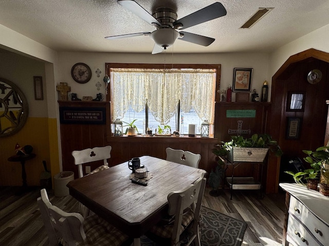 dining room featuring a textured ceiling, dark hardwood / wood-style floors, and ceiling fan