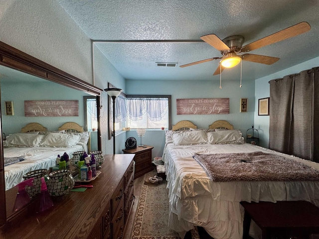 bedroom with wood-type flooring, a textured ceiling, and ceiling fan