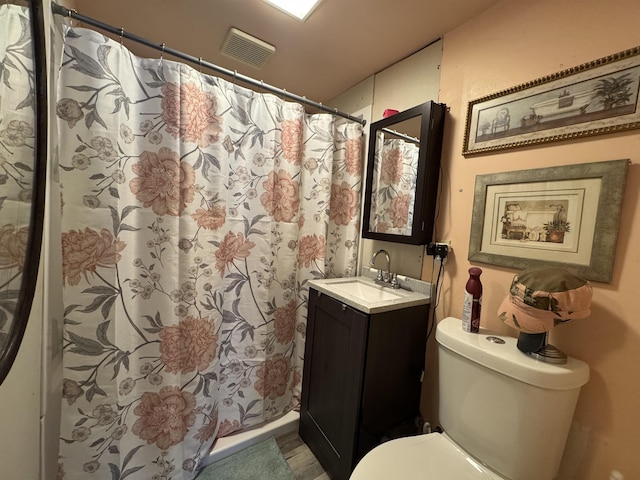 bathroom featuring vanity, toilet, and curtained shower