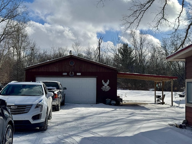 snow covered garage featuring a carport