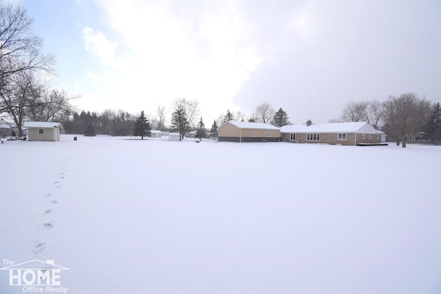 yard covered in snow with an outbuilding and a storage shed