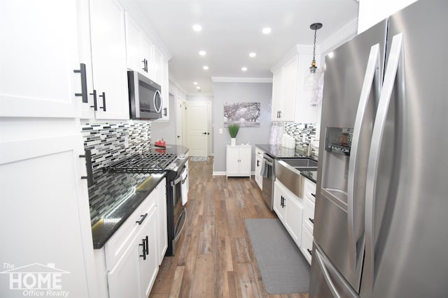 kitchen featuring white cabinetry, crown molding, wood finished floors, and appliances with stainless steel finishes