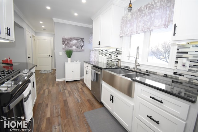 kitchen with a sink, stainless steel dishwasher, white cabinets, crown molding, and decorative backsplash