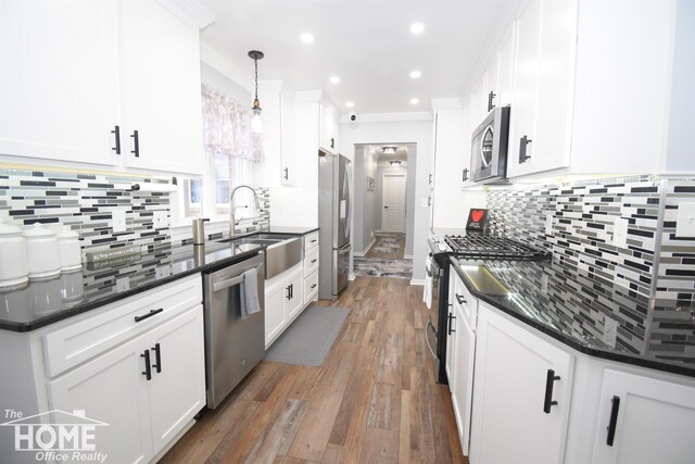 kitchen featuring decorative light fixtures, white cabinetry, dark hardwood / wood-style flooring, stainless steel appliances, and sink