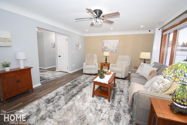 living room featuring dark wood-type flooring and ceiling fan