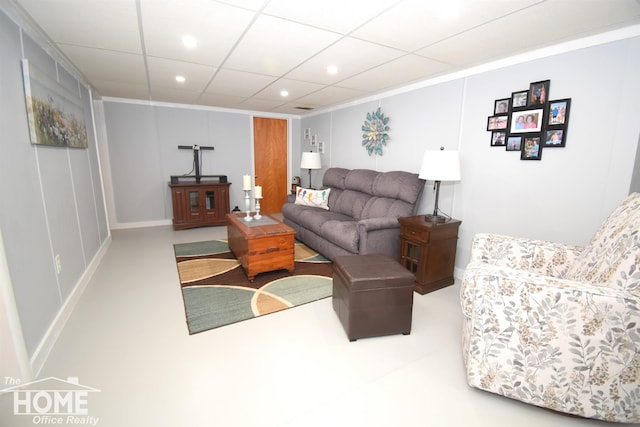 living area with a drop ceiling, recessed lighting, and baseboards