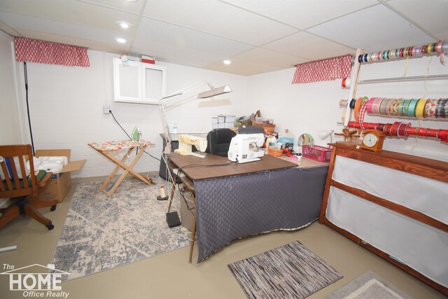 home office with concrete flooring and a drop ceiling