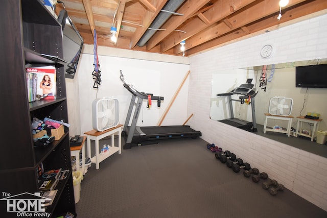 workout room featuring brick wall