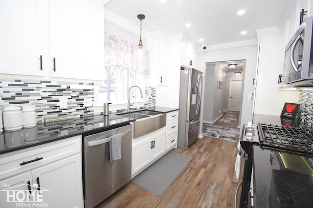 kitchen with sink, white cabinetry, hanging light fixtures, and stainless steel appliances