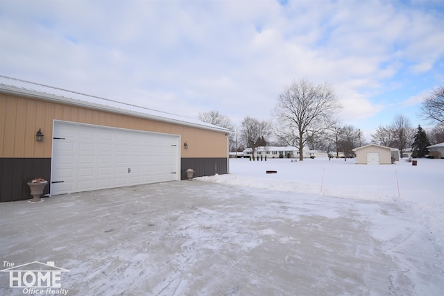 snow covered garage featuring a detached garage