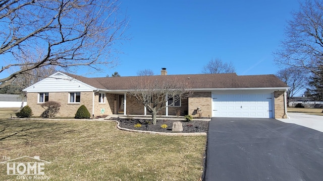 ranch-style home with a front yard, driveway, an attached garage, a chimney, and brick siding