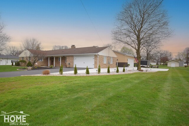 200 Elmwood Dr, Corunna, MI 48817 - rear view of house with driveway, a chimney, a lawn, a garage, and brick siding