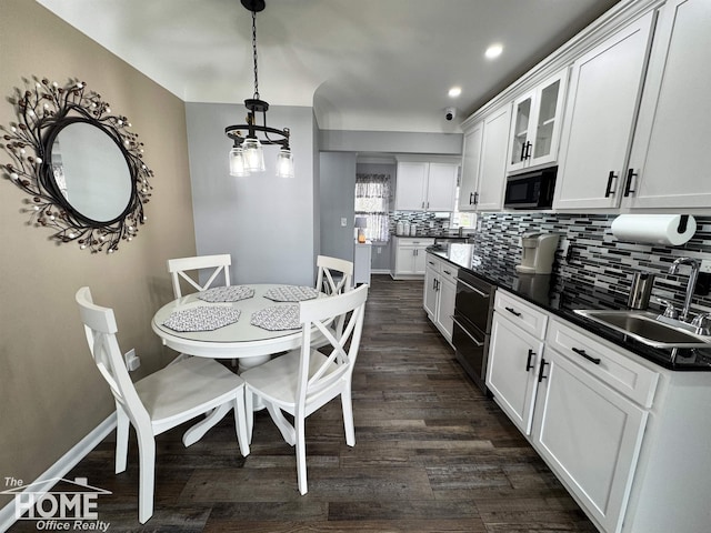 200 Elmwood Dr, Corunna, MI 48817 - kitchen featuring dark countertops, black microwave, a sink, white cabinetry, and backsplash