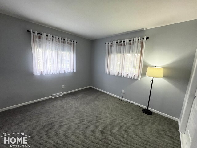 200 Elmwood Dr, Corunna, MI 48817 - spare room with baseboards, visible vents, and dark colored carpet