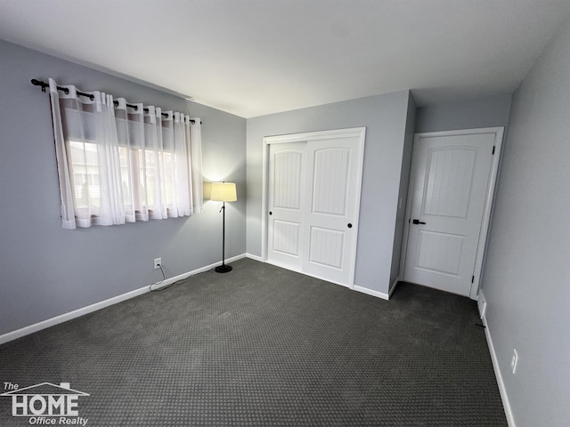 200 Elmwood Dr, Corunna, MI 48817 - unfurnished bedroom featuring baseboards, a closet, and dark carpet