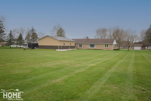 200 Elmwood Dr, Corunna, MI 48817 - back of property with a garage, a yard, and a chimney