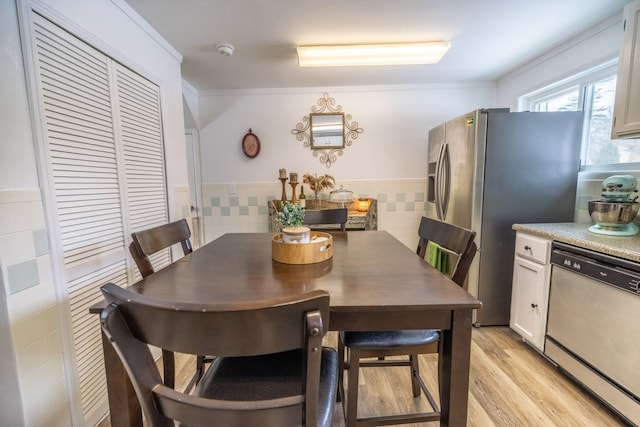 dining space with tile walls and light hardwood / wood-style flooring