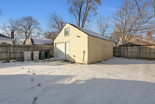 snow covered structure featuring a garage