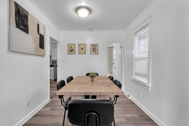 dining room with ornamental molding and hardwood / wood-style floors