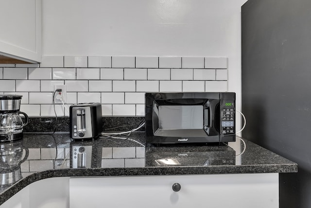 interior details with backsplash and white cabinets