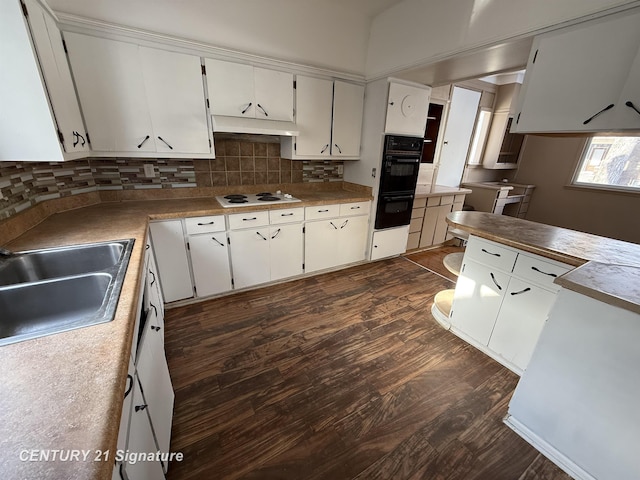 kitchen featuring white electric cooktop, sink, white cabinets, and backsplash