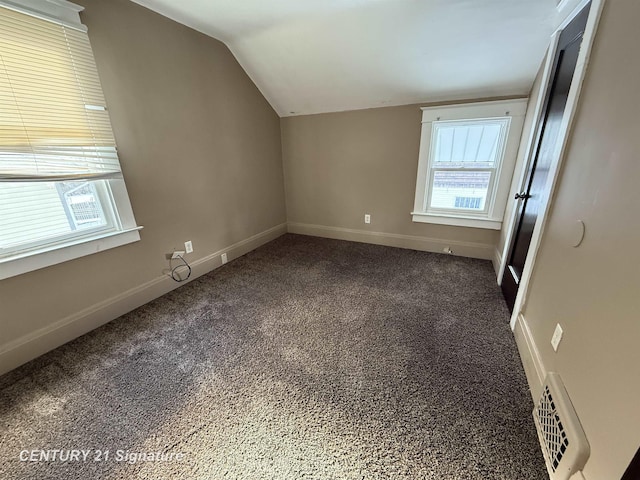 bonus room featuring vaulted ceiling and dark colored carpet