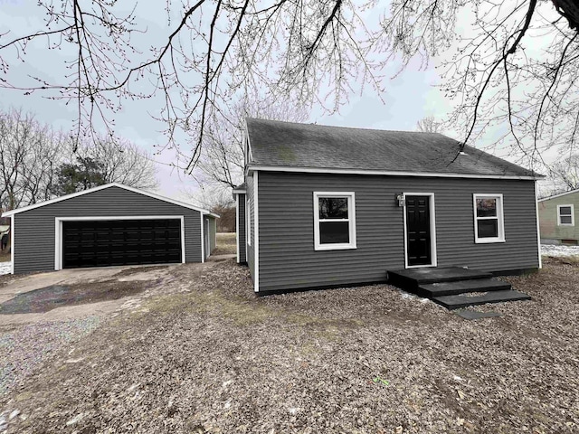 view of front of home featuring a garage and an outbuilding