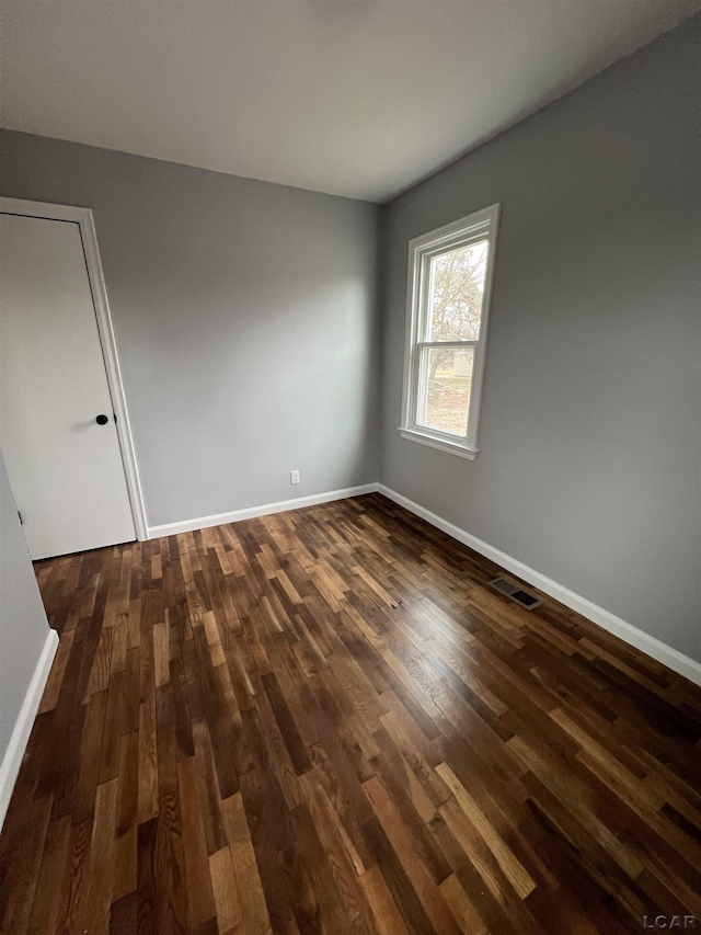 empty room with dark wood-type flooring