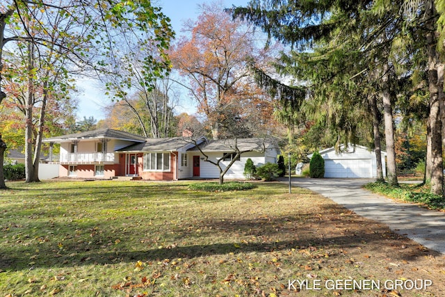 tri-level home with a garage, an outdoor structure, and a front lawn